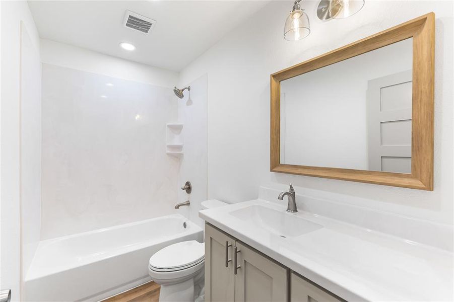 Bathroom with toilet, vanity, shower combination, and wood finished floors Bathroom with toilet, vanity, shower combination, and wood finished floors