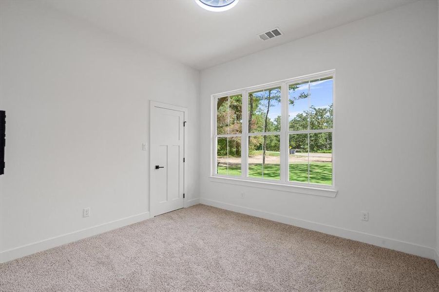 Empty room featuring light colored carpet and baseboards Empty room featuring light colored carpet and baseboards