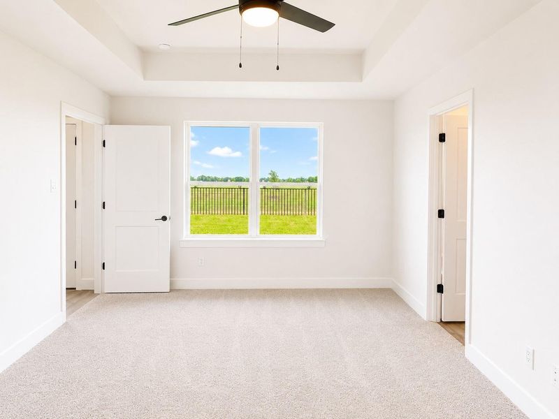Secondary bedroom featuring plush carpeting, soft natural light, and a comfortable layout perfect for guests, family, or a home office.