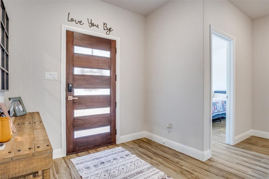 Entrance foyer with baseboards and light wood-style floors
