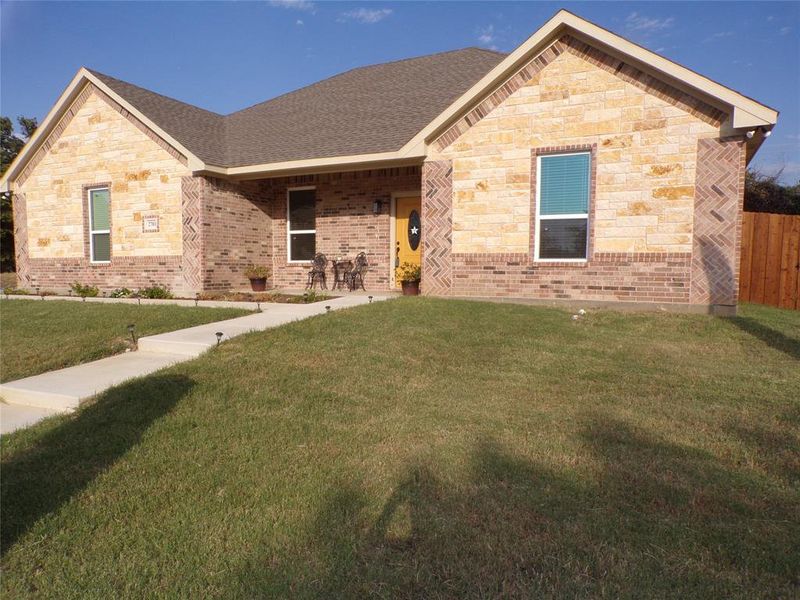 View of front of property featuring a patio area and a front lawn