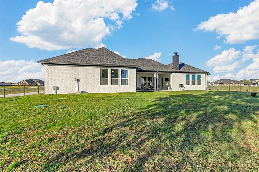 Rear view of property featuring a lawn