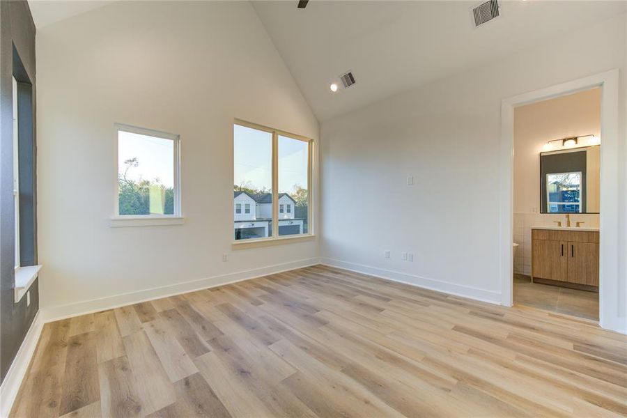 Primary bedroom features cathedral ceilings and lots of windows for natural light!