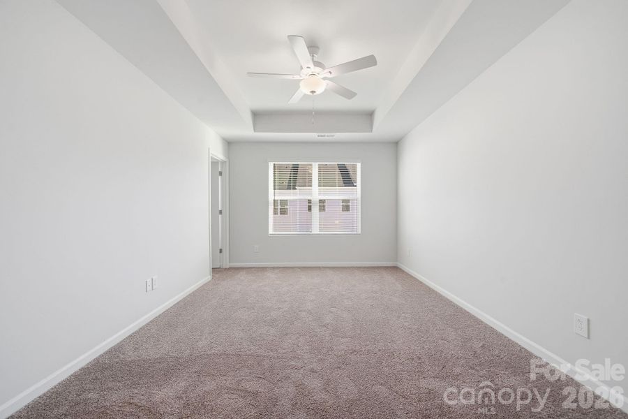 Primary Bedroom with 9' Tray Ceiling Primary Bedroom with 9' Tray Ceiling