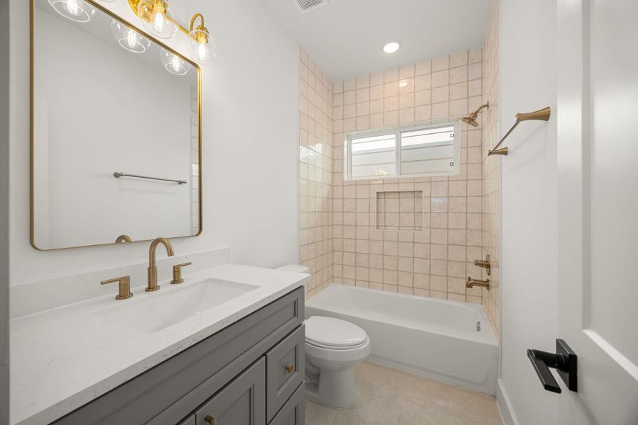 Secondary bathroom features light countertops and grey cabinets, neutral paint, shower/tub combo with tile surround, large mirror, tile floors, sleek fixtures and modern finishes with plenty of space to accommodate any visiting family or guests. Secondary bathroom features light countertops and grey cabinets, neutral paint, shower/tub combo with tile surround, large mirror, tile floors, sleek fixtures and modern finishes with plenty of space to accommodate any visiting family or guests.