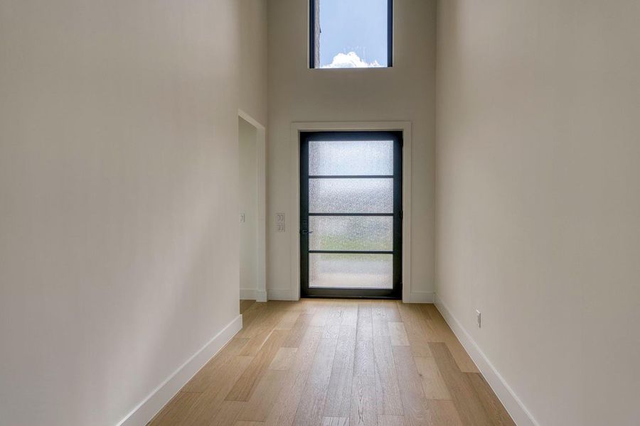 Clean lines and warm wood floors define this welcoming entry with soaring ceilings.