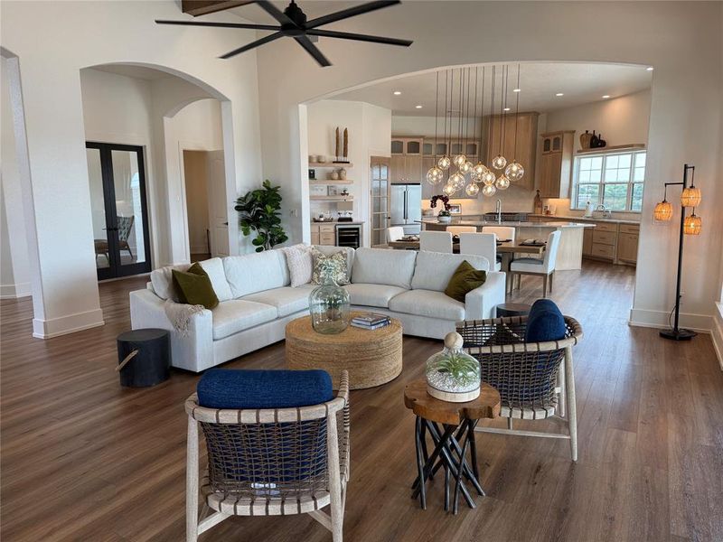Living area featuring dark wood finished floors, recessed lighting, a chandelier, arched walkways, and a ceiling fan Living area featuring dark wood finished floors, recessed lighting, a chandelier, arched walkways, and a ceiling fan