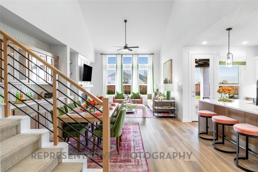 Living area with a ceiling fan, light wood-style floors, recessed lighting, stairway, and high vaulted ceiling