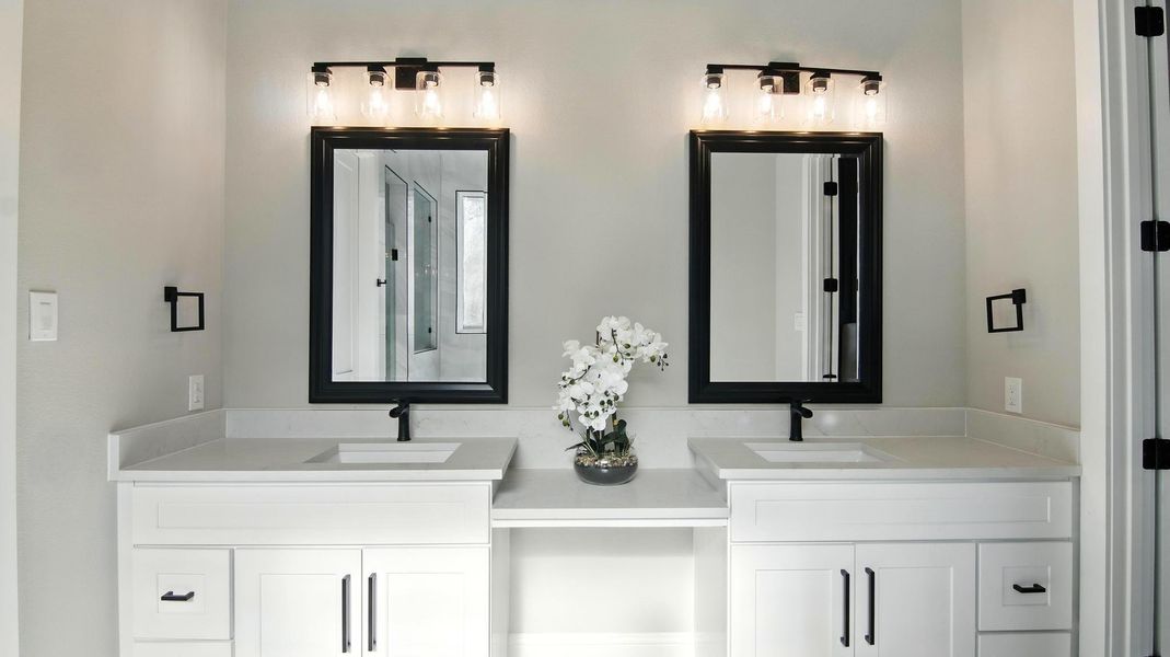Step into this sophisticated spa-inspired bathroom featuring a dual vanity with sleek white cabinetry, quartz countertops, and matte black fixtures for a contemporary touch. Step into this sophisticated spa-inspired bathroom featuring a dual vanity with sleek white cabinetry, quartz countertops, and matte black fixtures for a contemporary touch.