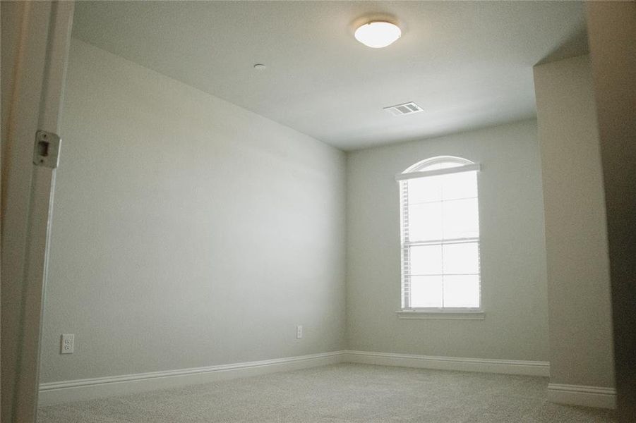 Empty room featuring light carpet