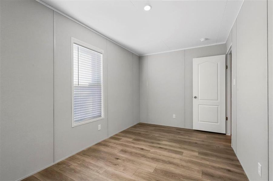 Spare room with wood finished floors and ornamental molding