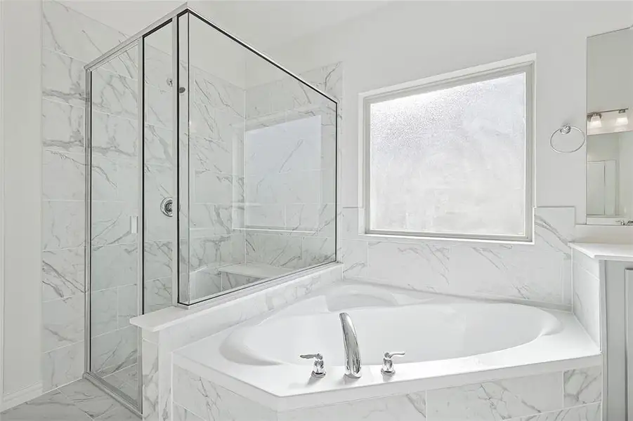 Bathroom with a marble finish shower, a garden tub, and vanity Bathroom with a marble finish shower, a garden tub, and vanity