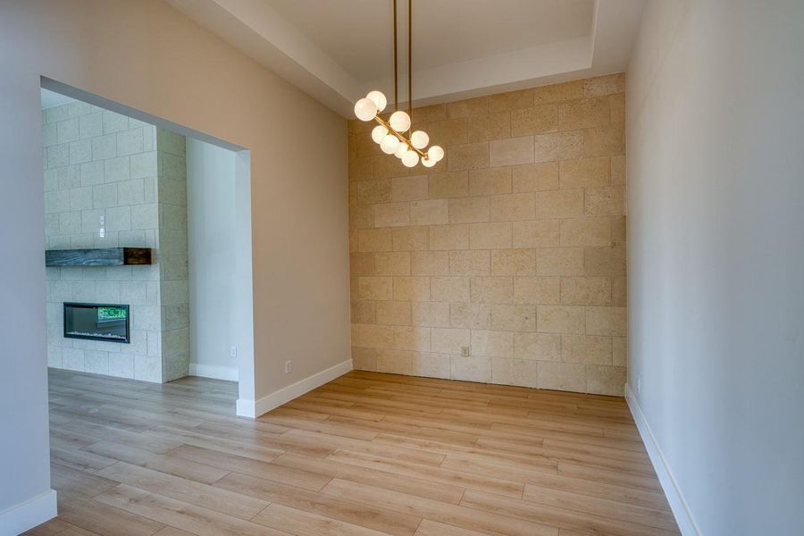 Artfully illuminated, this area features striking wood flooring and a stone-accented wall.