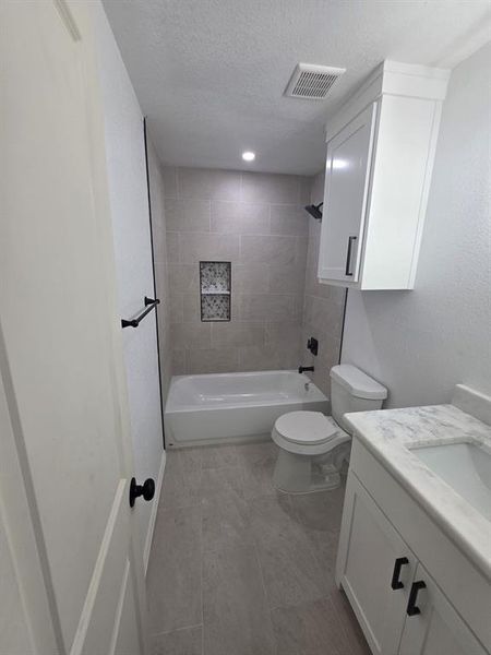 Bathroom with vanity, a textured ceiling, and bathing tub / shower combination Bathroom with vanity, a textured ceiling, and bathing tub / shower combination