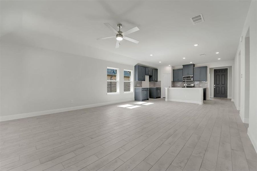 Unfurnished living room featuring ceiling fan, recessed lighting, visible vents, baseboards, and light wood-type flooring