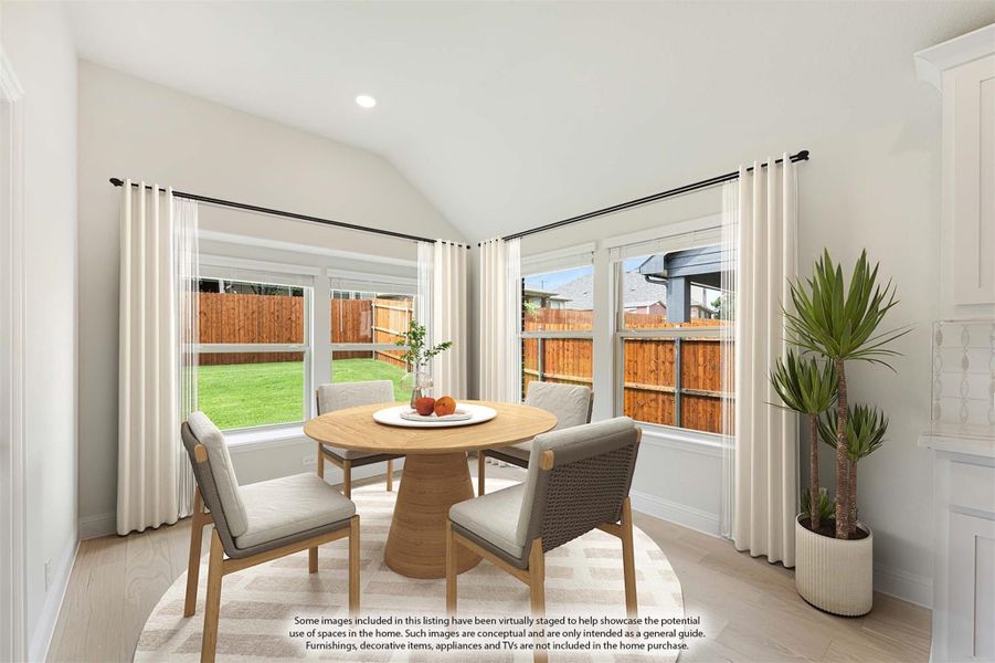 Bright dining nook with vaulted ceiling, round wood table, four chairs, and large windows overlooking backyard Bright dining nook with vaulted ceiling, round wood table, four chairs, and large windows overlooking backyard