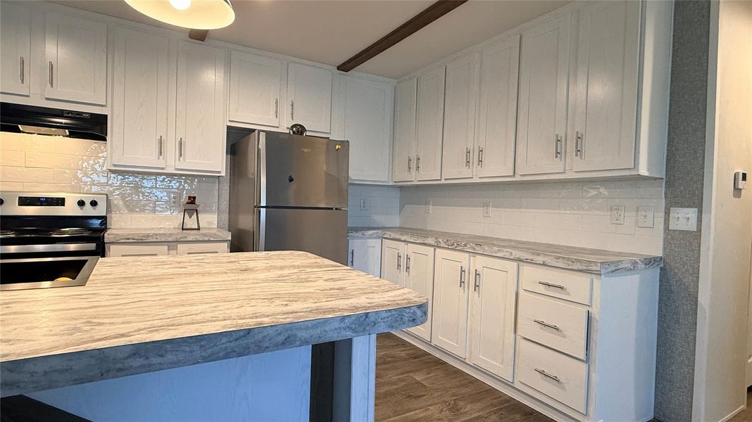 A well-appointed kitchen features ample white cabinetry, sleek countertops, and modern appliances. A well-appointed kitchen features ample white cabinetry, sleek countertops, and modern appliances.