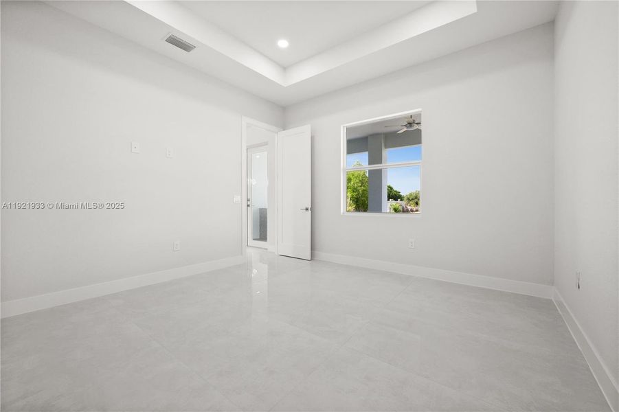 Spare room featuring a raised ceiling, light tilepatterned floors, and recessed lighting Spare room featuring a raised ceiling, light tilepatterned floors, and recessed lighting