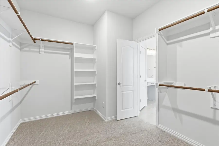 Spacious closet featuring light colored carpet Spacious closet featuring light colored carpet