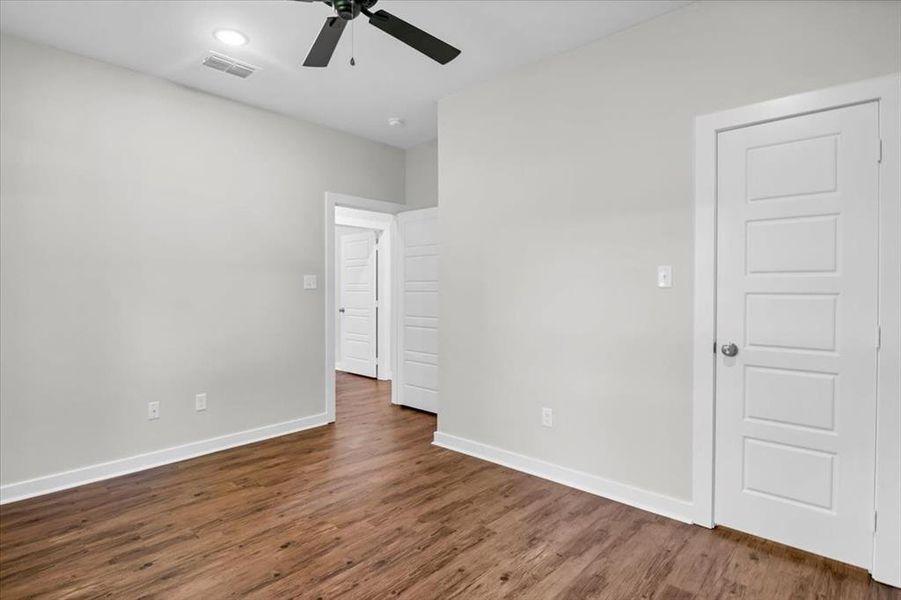 Unfurnished bedroom featuring baseboards, wood finished floors, and a ceiling fan