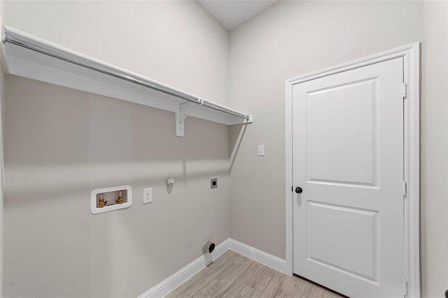 Laundry area featuring gas dryer hookup, light wood-type flooring, washer hookup, and electric dryer hookup