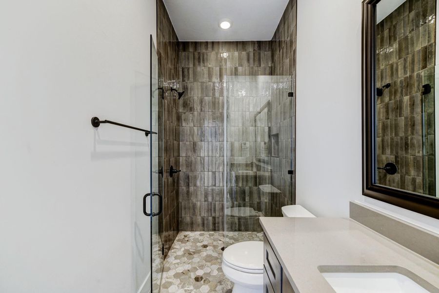 Front bedroom en suite bath with modern floor to ceiling tile in the walk in shower.