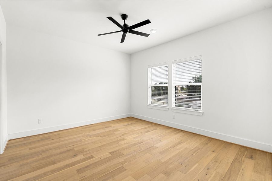 Spacious bedroom featuring a full walk-in closet and a private en-suite bath, offering both comfort and functionality for guests or family members.