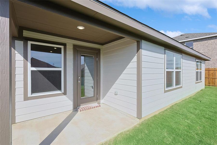 Doorway to property featuring a yard and a patio