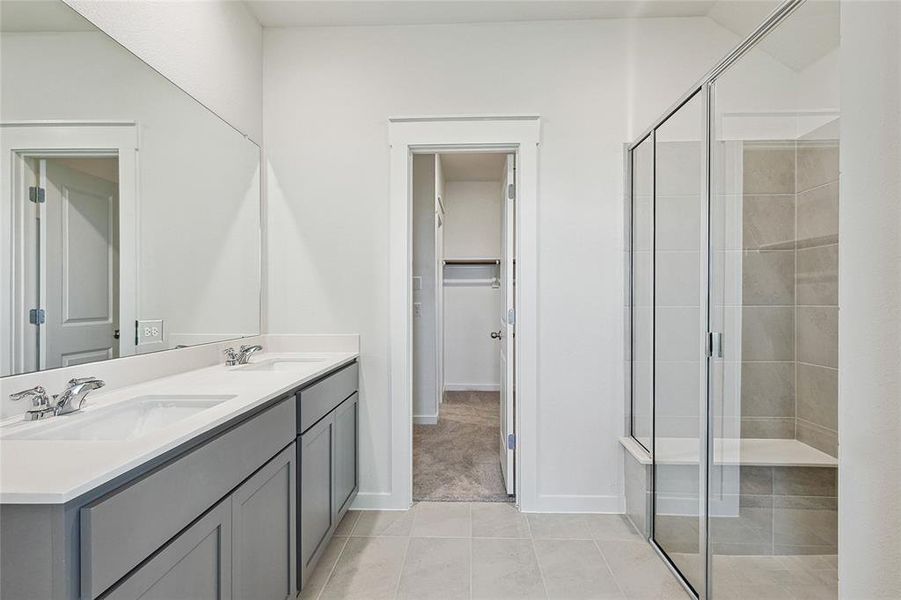 Bathroom featuring tile patterned flooring, an enclosed shower, and vanity