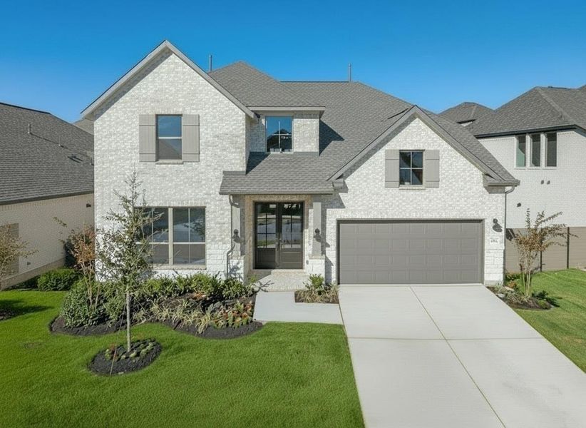 View of front of property with brick siding, driveway, and a front lawn