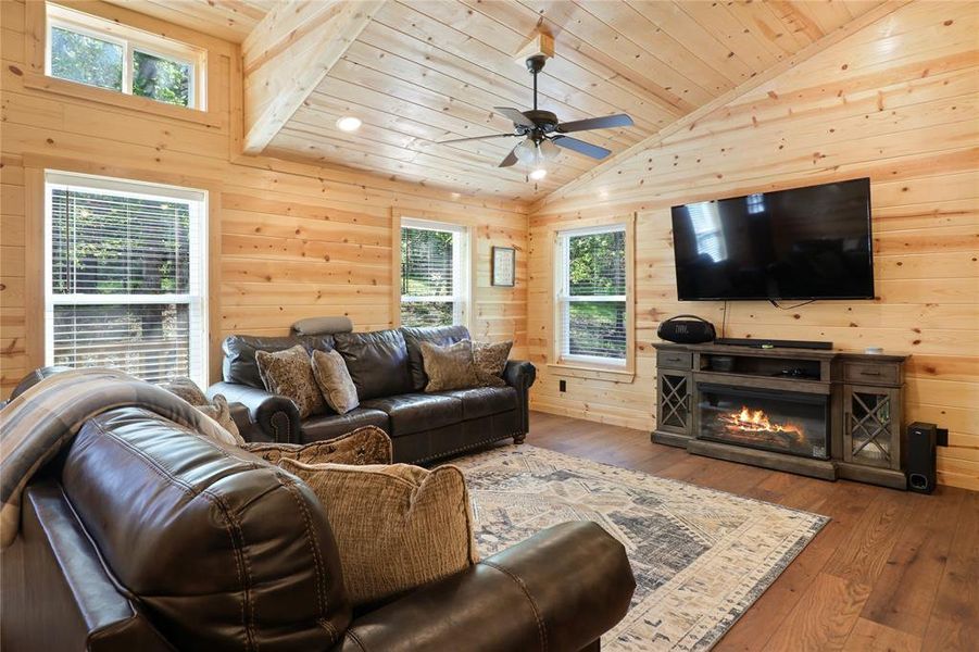 Living room with lofted ceiling, wood ceiling, ceiling fan, and hardwood / wood-style floors