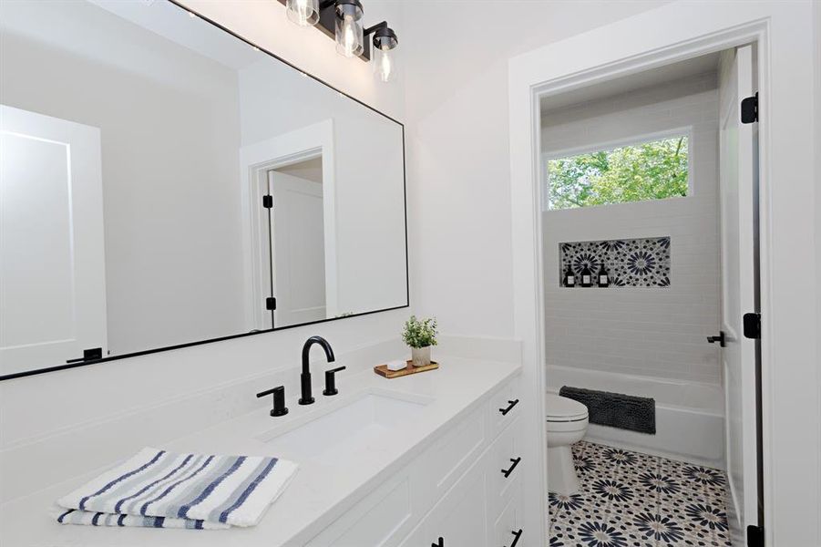 Bright and Modern Guest Bathroom offers designer tile floors and accents. Bright and Modern Guest Bathroom offers designer tile floors and accents.