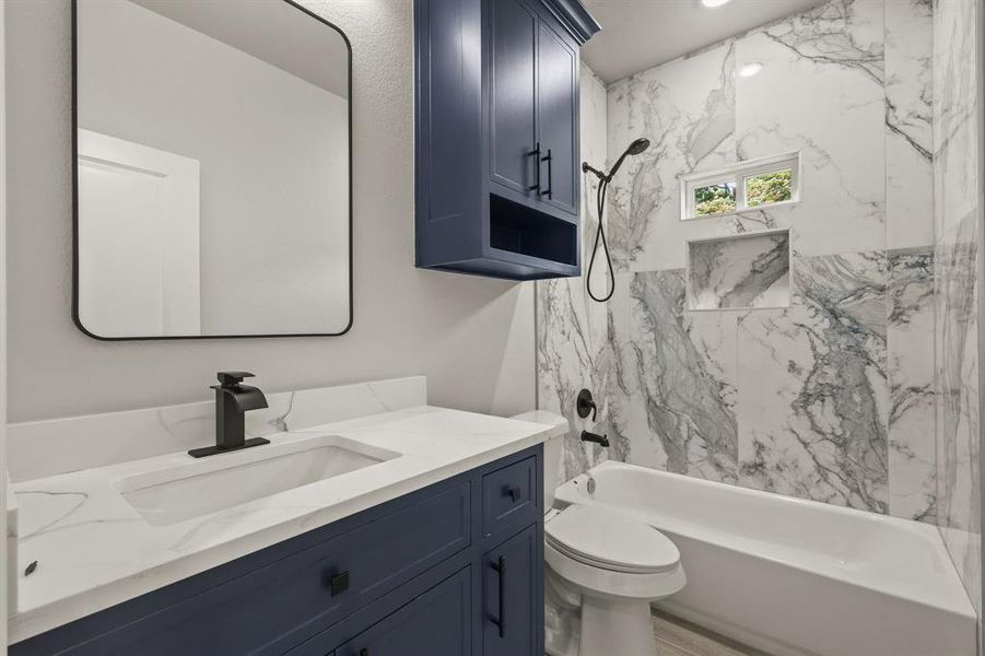 Bathroom featuring vanity, shower / washtub combination, and toilet