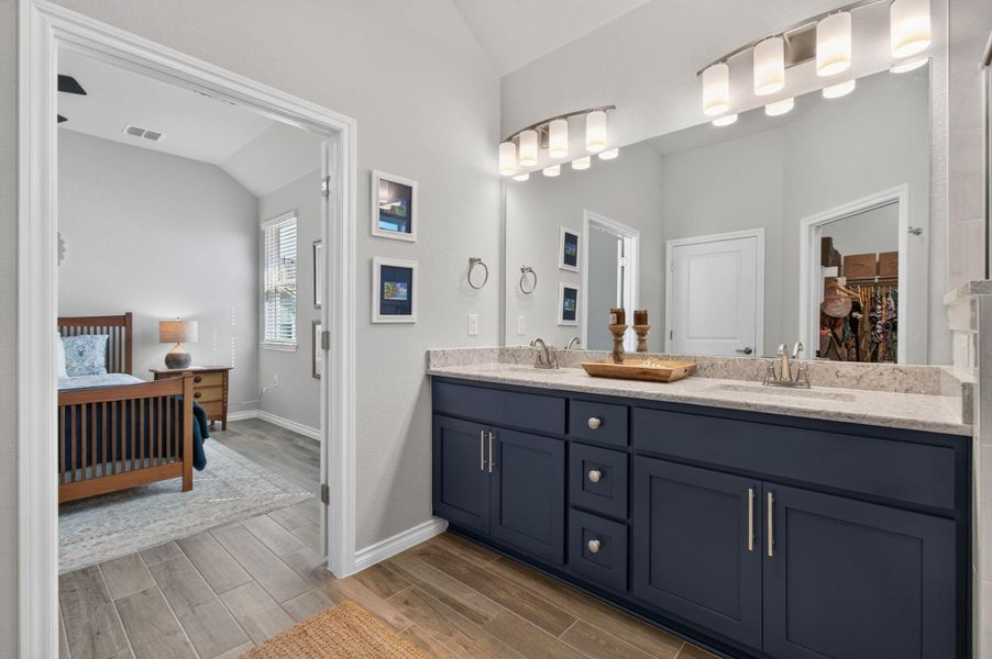 A chic primary bathroom vanity with dual sinks, modern cabinetry, and ample lighting. A chic primary bathroom vanity with dual sinks, modern cabinetry, and ample lighting.