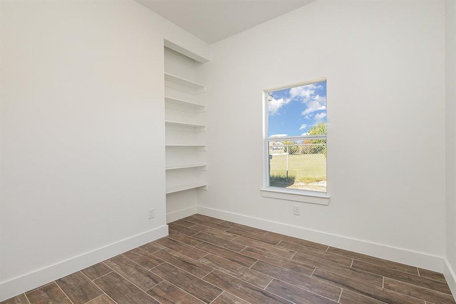 Spare room with baseboards and wood finish floors