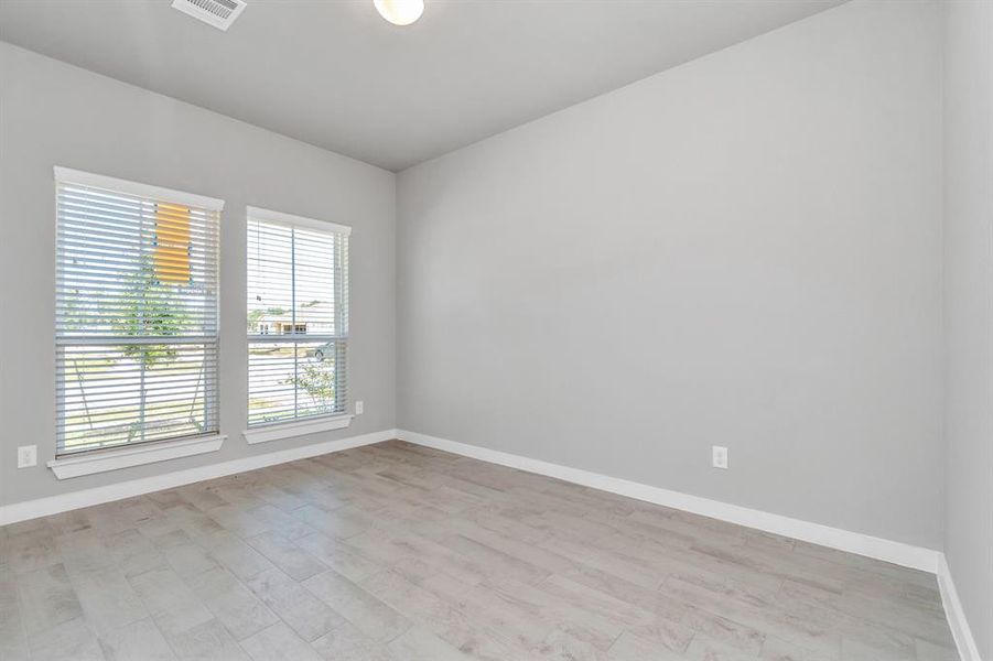 Quietly nestled in front of the home is the sophisticated home office. Featuring elegant floors, custom paint and large window with privacy blinds. Sample photo of completed home with similar floor plan. As-built interior colors and selections may vary