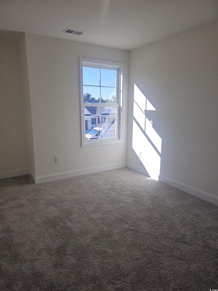 Empty room with carpet flooring and baseboards