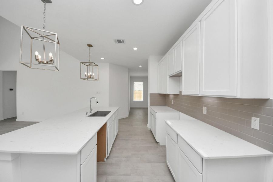 The extended counter area adds both practicality and style, making meal preparation a breeze. Every detail is thoughtfully designed to enhance the kitchen's functionality and aesthetic appeal. Sample photo of completed home with similar floor plan. Actual colors and selections may vary. The extended counter area adds both practicality and style, making meal preparation a breeze. Every detail is thoughtfully designed to enhance the kitchen's functionality and aesthetic appeal. Sample photo of completed home with similar floor plan. Actual colors and selections may vary.
