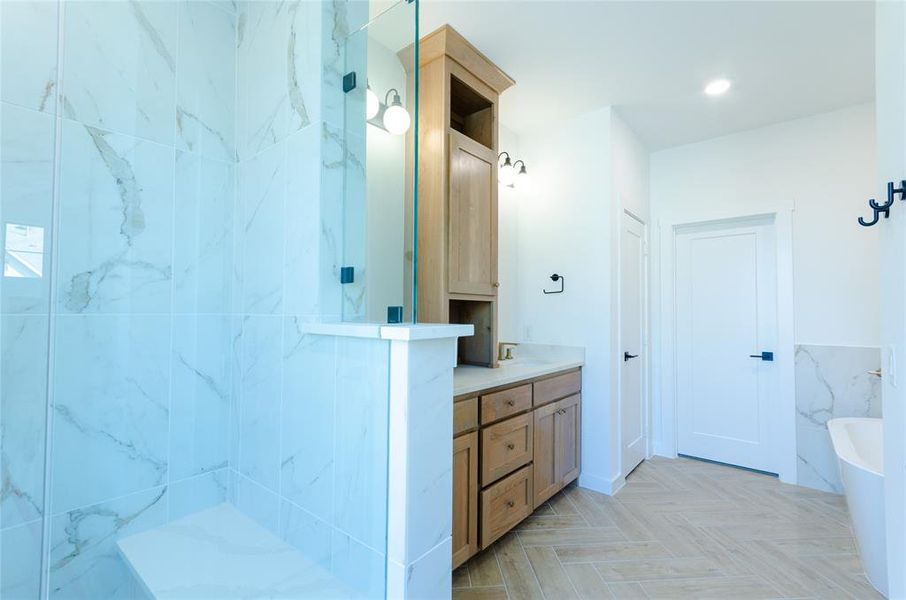 Bathroom featuring vanity, a marble finish shower, a tub, and tile walls