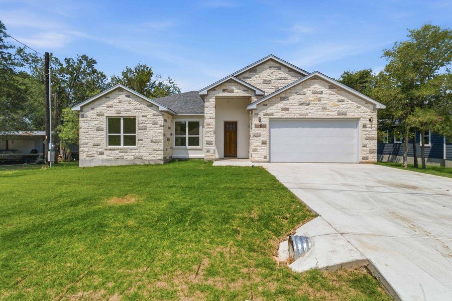 A newly constructed residence features a crisp white garage door, complementing its light-colored stone facade and welcoming front entrance. A newly constructed residence features a crisp white garage door, complementing its light-colored stone facade and welcoming front entrance.