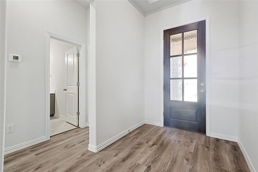 Doorway with baseboards and wood finished floors Doorway with baseboards and wood finished floors