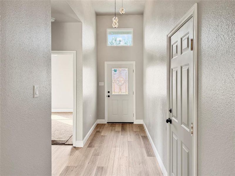 Entryway featuring a textured wall and light wood-style flooring Entryway featuring a textured wall and light wood-style flooring