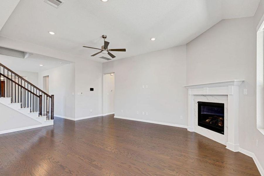 Unfurnished living room featuring recessed lighting, dark wood-style floors, a fireplace, stairway, and ceiling fan Unfurnished living room featuring recessed lighting, dark wood-style floors, a fireplace, stairway, and ceiling fan