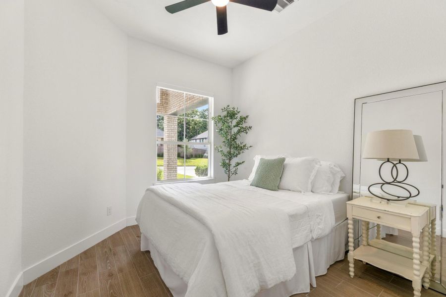 Bright and airy secondary bedroom featuring natural light, a ceiling fan, and elegant tile flooring. Bright and airy secondary bedroom featuring natural light, a ceiling fan, and elegant tile flooring.