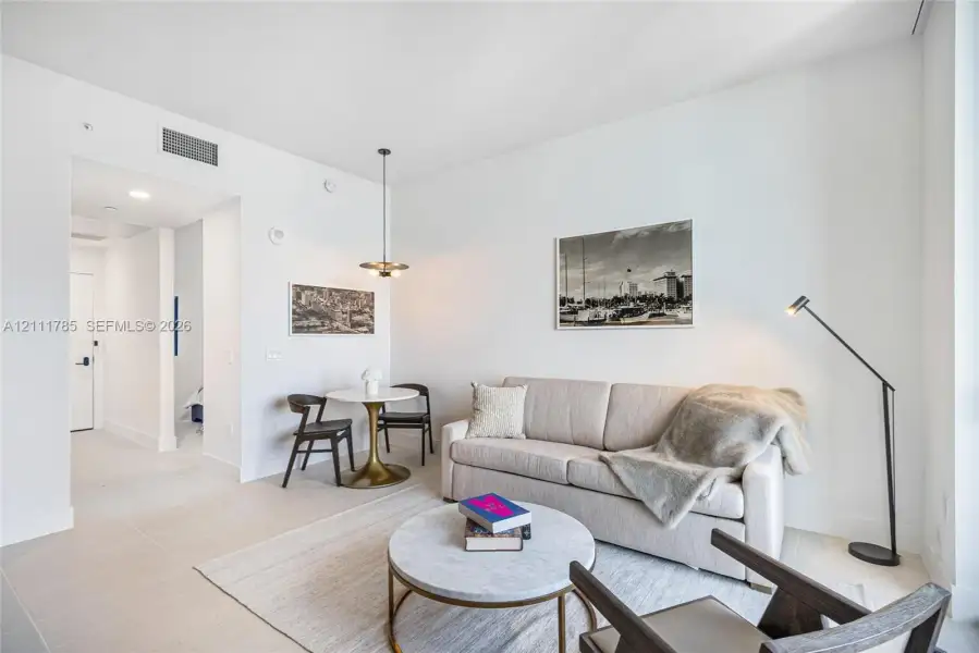 High ceilings featuring neutral wall finishes, tile flooring, and a contemporary multi-bulb pendant fixture