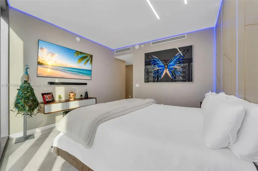 Interior space featuring recessed linear ceiling lighting, perimeter ambient cove lighting, tile flooring, and integrated wall paneling Interior space featuring recessed linear ceiling lighting, perimeter ambient cove lighting, tile flooring, and integrated wall paneling