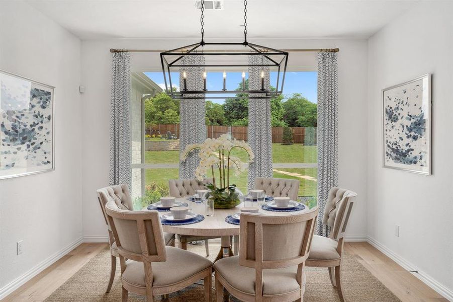 Dining space with light hardwood / wood-style floors and an inviting chandelier