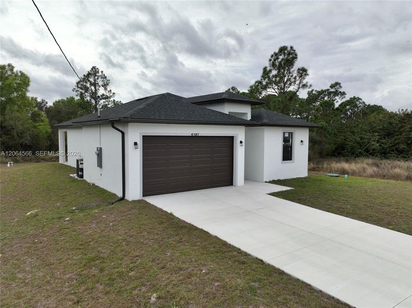 Front exterior of a new home in , Lehigh Acres, FL, highlighting curb appeal (Image 26). Front exterior of a new home in , Lehigh Acres, FL, highlighting curb appeal (Image 26).