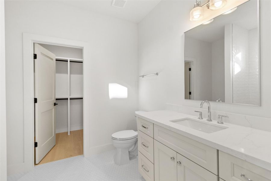 Your bathroom feels bright and refined with a quartz-topped vanity, ample storage, and polished fixtures that elevate the space without feeling overdone. Direct access to the walk-in closet adds everyday convenience, creating a seamless flow that makes your morning and evening routines feel easy and organized.