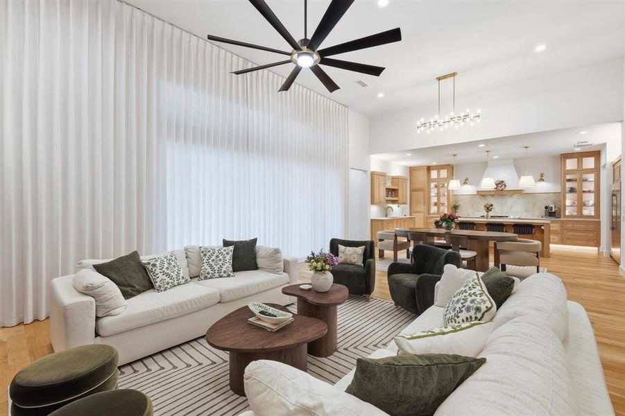 Living room featuring light wood-style flooring, a ceiling fan, and recessed lighting